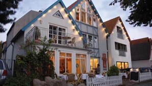 A two-story building with a balcony and a dining area visible through the windows. - Vogel Hotel Appartements & Spa (Rostock)