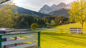 A view of a mountain landscape with a white fence and a building in the foreground. - Landhaus Bergrast (Ramsau am Dachstein)