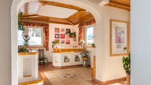 A cozy kitchen with wooden beams, a central island, and various plants. - Landhaus Bergrast (Ramsau am Dachstein)