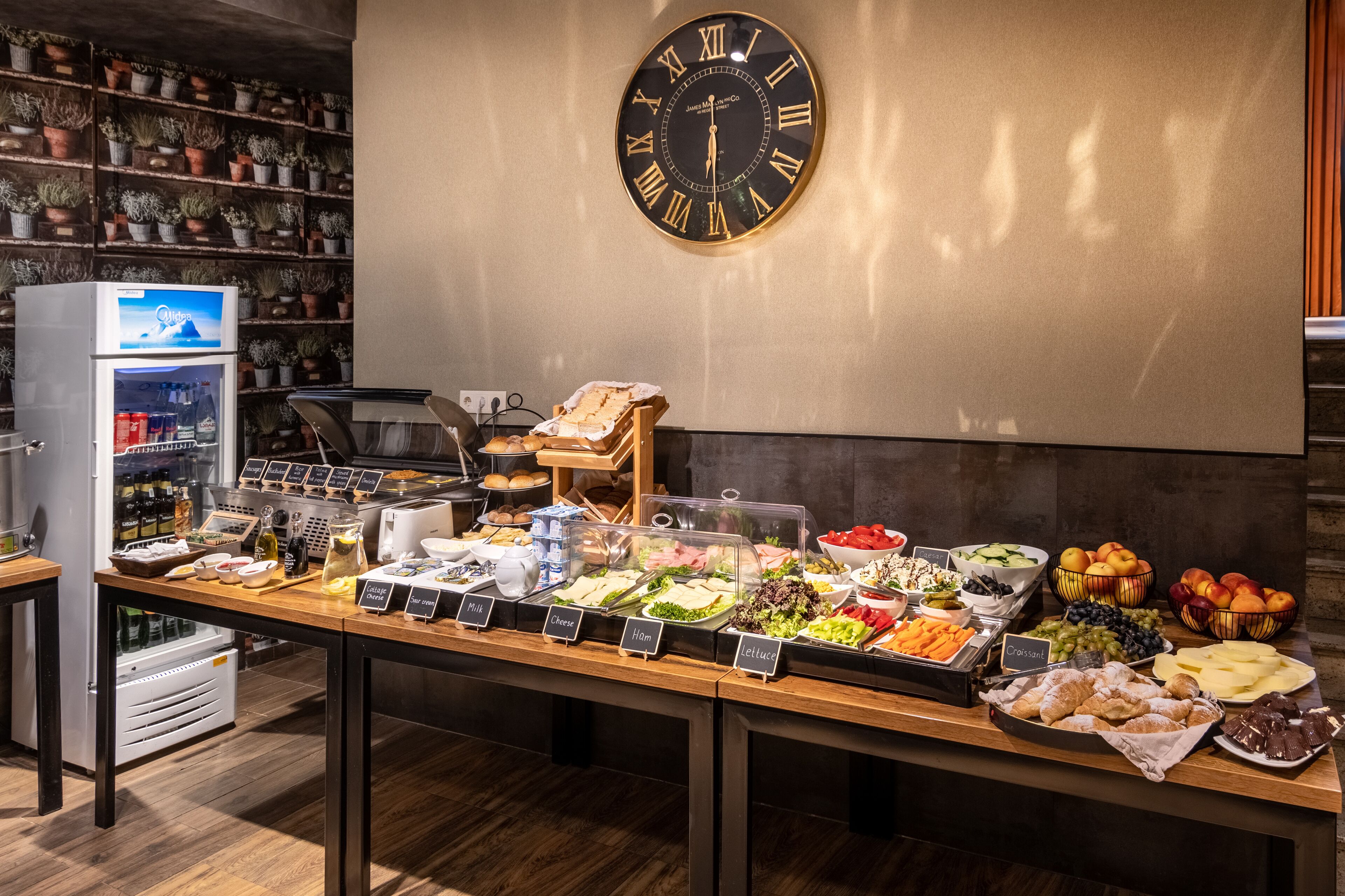 A buffet with various food options and a clock on the wall.