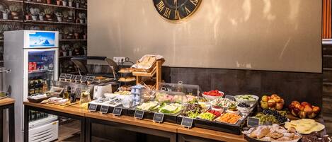 A buffet with various food options and a clock on the wall.