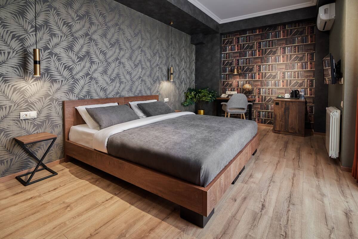 A modern bedroom with a wooden bed, a bookshelf, and a desk.