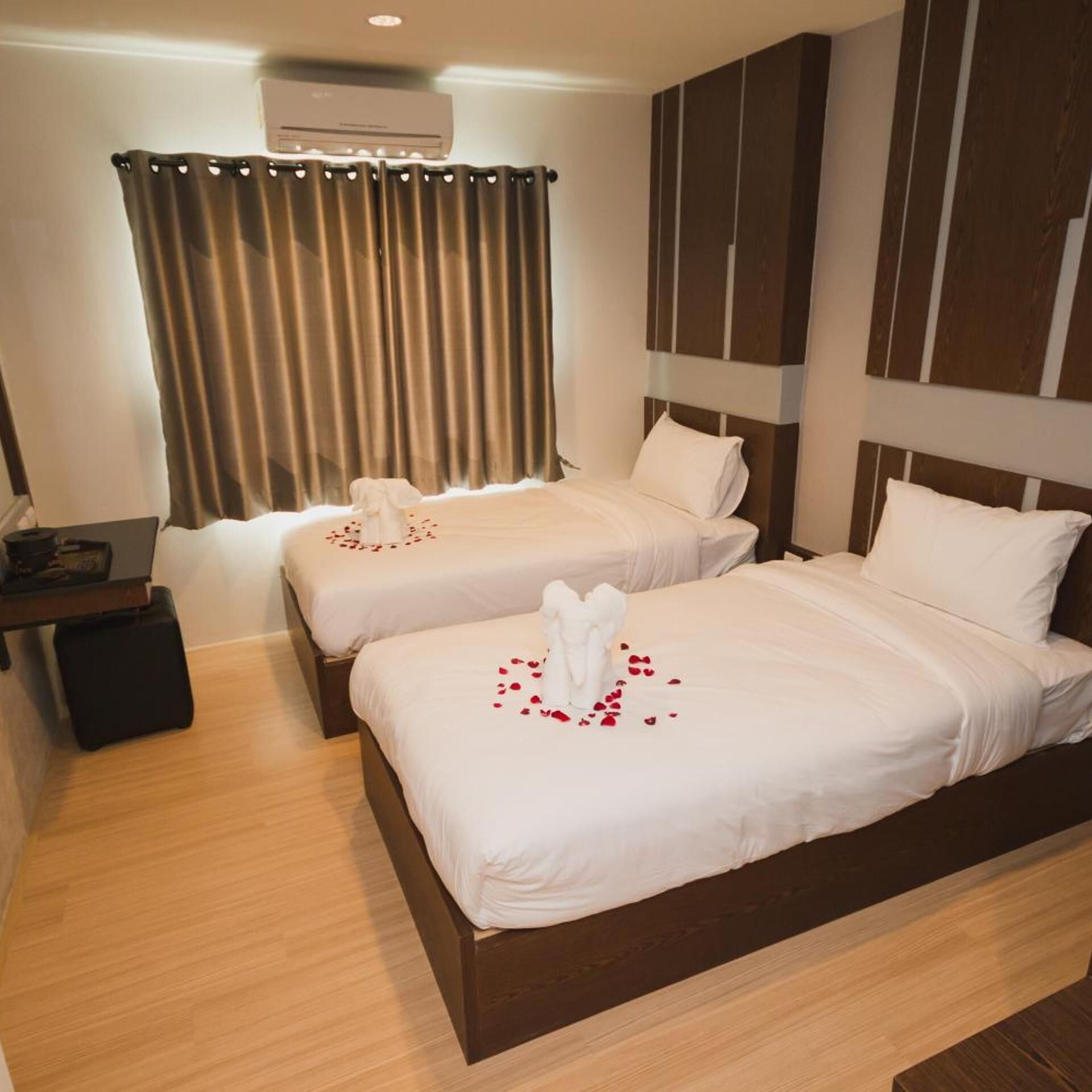 Ein Hotelzimmer mit zwei Betten, einem Schreibtisch und einem Vorhang.
