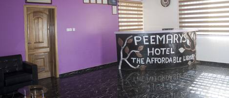 Un'area di accoglienza con una reception che recita: 'PEEMARY'S HOTEL THE AFFORDABLE LUXURY'.