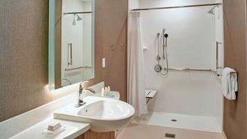 A modern bathroom with a sink, mirror, and shower.