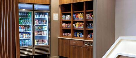 A snack bar with refrigerated drinks and a variety of snacks.