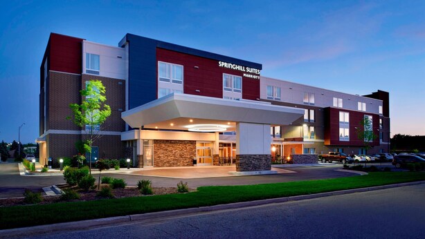 A modern hotel with a prominent entrance, multiple floors, and a well-lit facade. - Springhill Suites Grand Rapids West (Grandville)