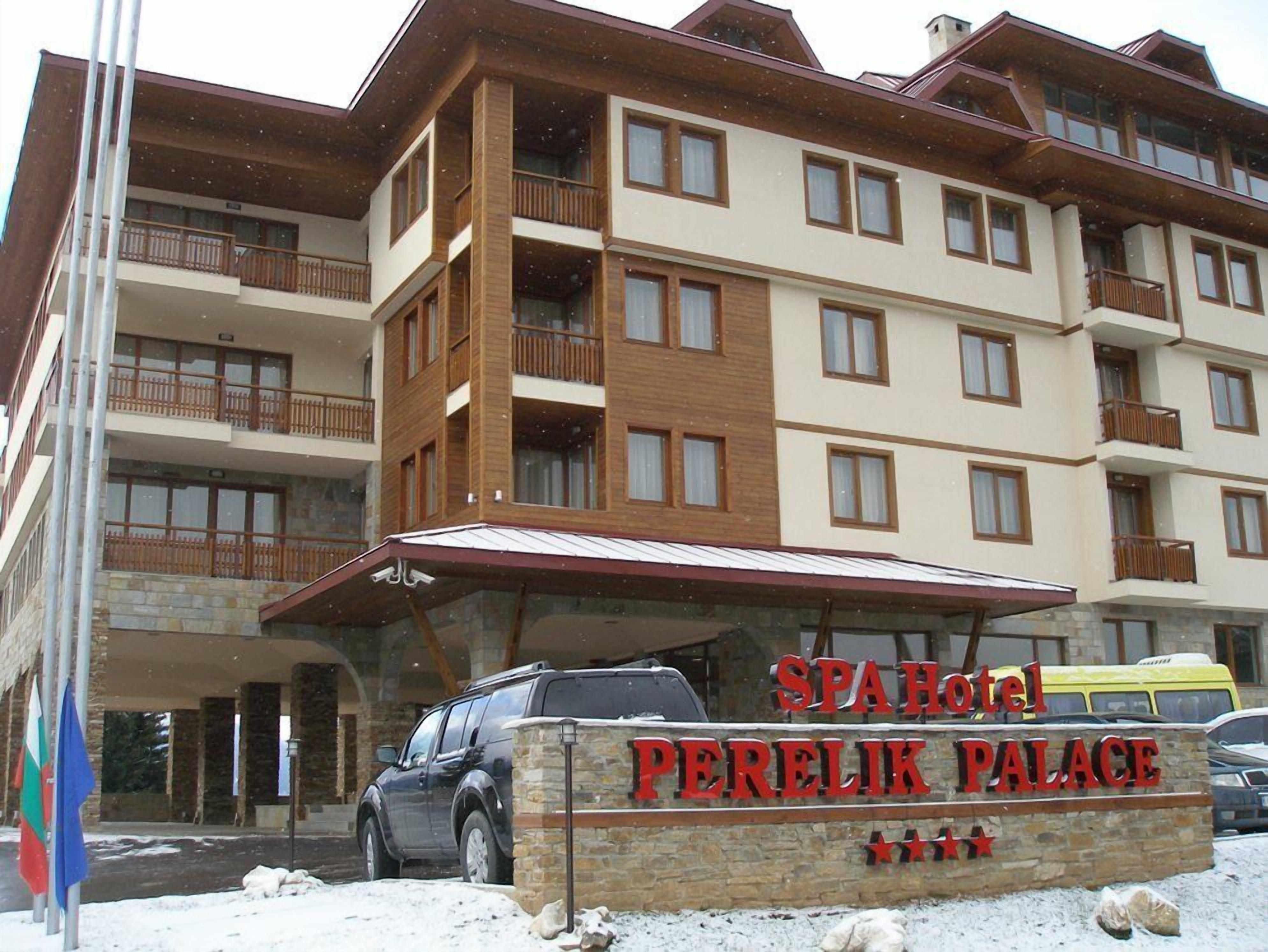 Een meerlaags hotel genaamd SPAHOTEL PERELIK PALACE met een stenen gevel, balkons en een overdekte entree.