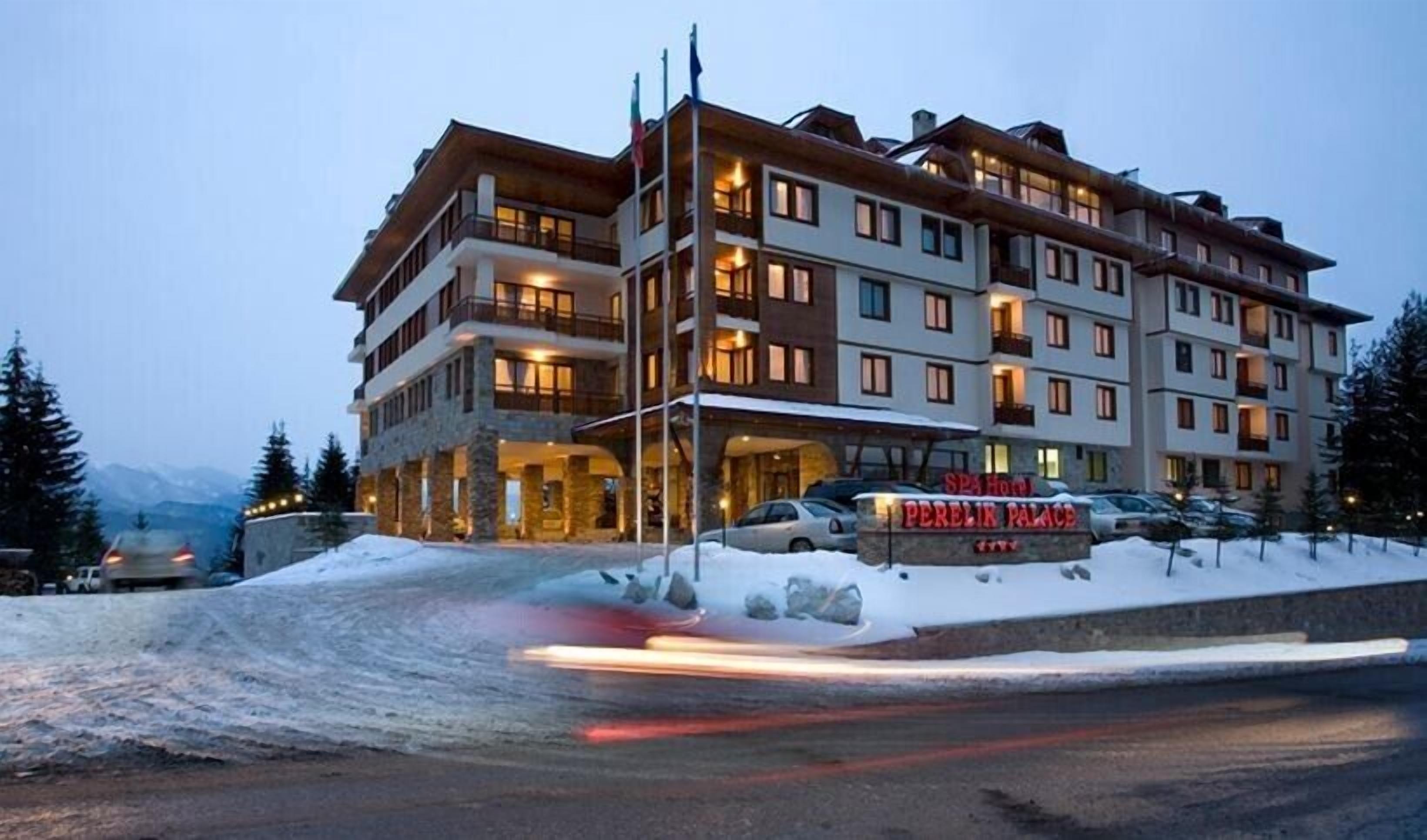 Ein mehrstöckiges Hotel mit Stein-Fassade, Balkonen und einem Schild mit der Aufschrift "SPA HOTEL PERELIK PALACE".