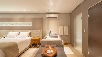 Een moderne hotelkamer met een bed, nachtkastje, kaptafel met spiegel en een uniek houten decoratiestuk.