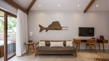 Una sala de estar moderna con un sofá, un televisor, un escritorio de madera y una gran pieza de arte mural con motivos de peces.