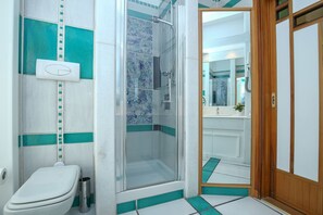 Un baño con inodoro, ducha y espejo.