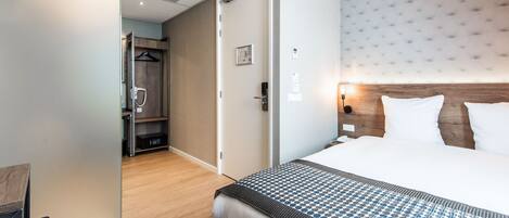 Een hotelkamer met een groot bed, een kledingkast en een inloopkast.