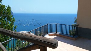 A balcony with a view of the sea, a wooden railing, and tiled flooring. - Castello Mezzacapo by Starhost (Scala)