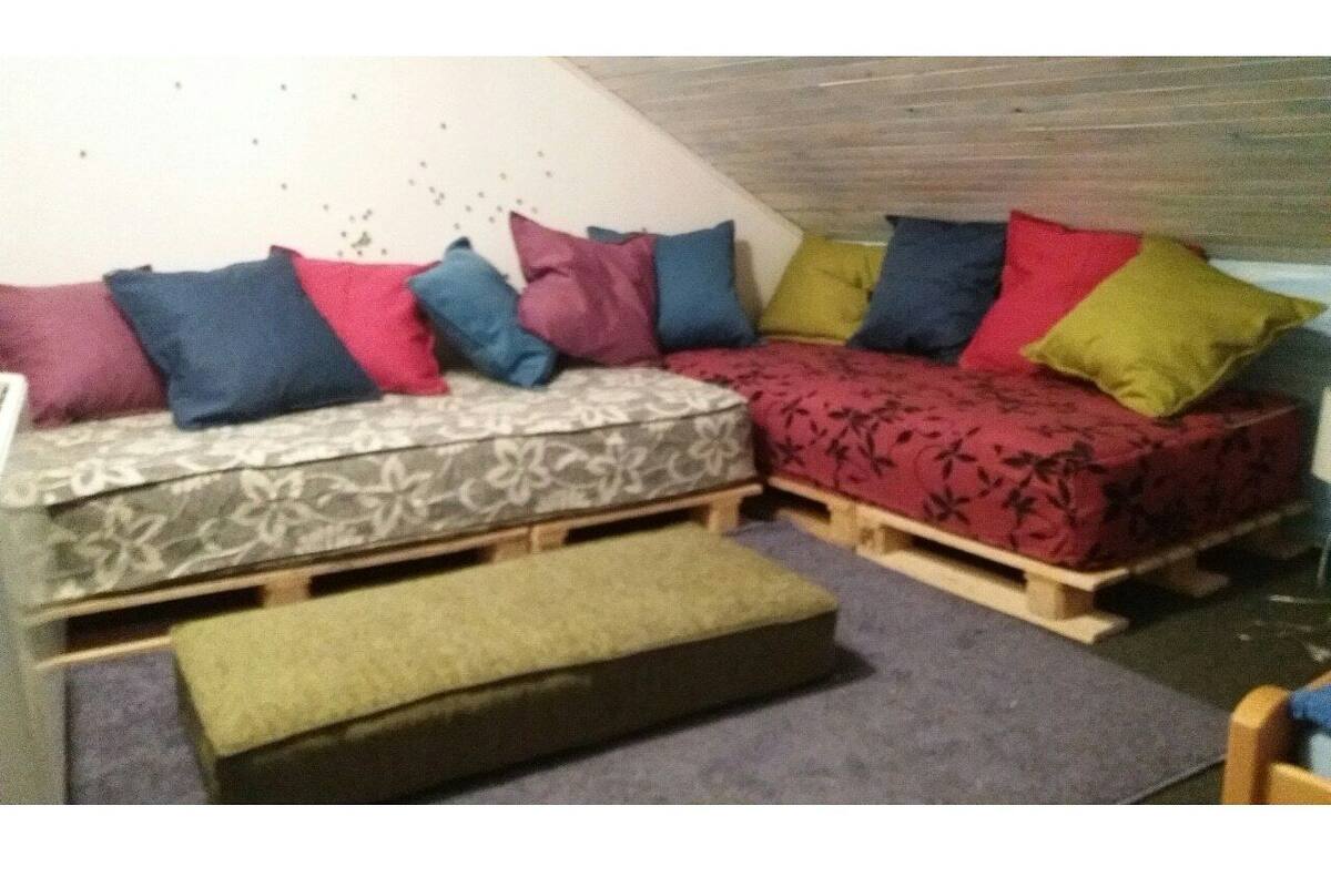 Um sofá confortável e espaçoso com almofadas coloridas em um quarto com teto inclinado.