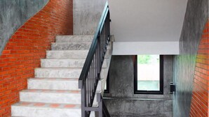 Una escalera con diseño curvo, barandilla de metal y un ventanal en la parte superior.