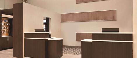 A reception area with a modern design, featuring a reception desk, a counter, and a wall-mounted information board.