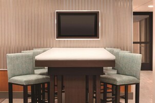 A dining area with a rectangular table and four upholstered chairs.