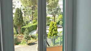 A window with a view of a courtyard, a radiator below, and a metal gate with a "No Parking" sign. - Il Sampietrino dei Cavalleggeri B&B (Rome)