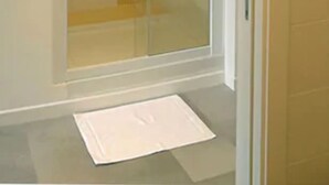 A glass-enclosed shower room with a tiled floor and a white mat. - Il Sampietrino dei Cavalleggeri B&B (Rome)