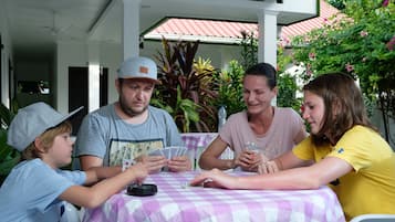 Un grupo de personas jugando cartas en una mesa con mantel a cuadros.