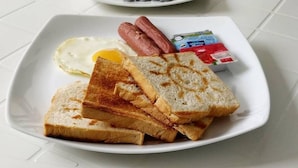 A breakfast plate with toast, a fried egg, and a sausage. - Athiriveli (Thoddoo)