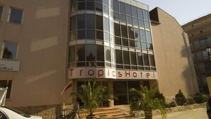 A Tropic Hotel with a modern glass facade and a flag. - Tropics Hotel (Sveti Vlas)