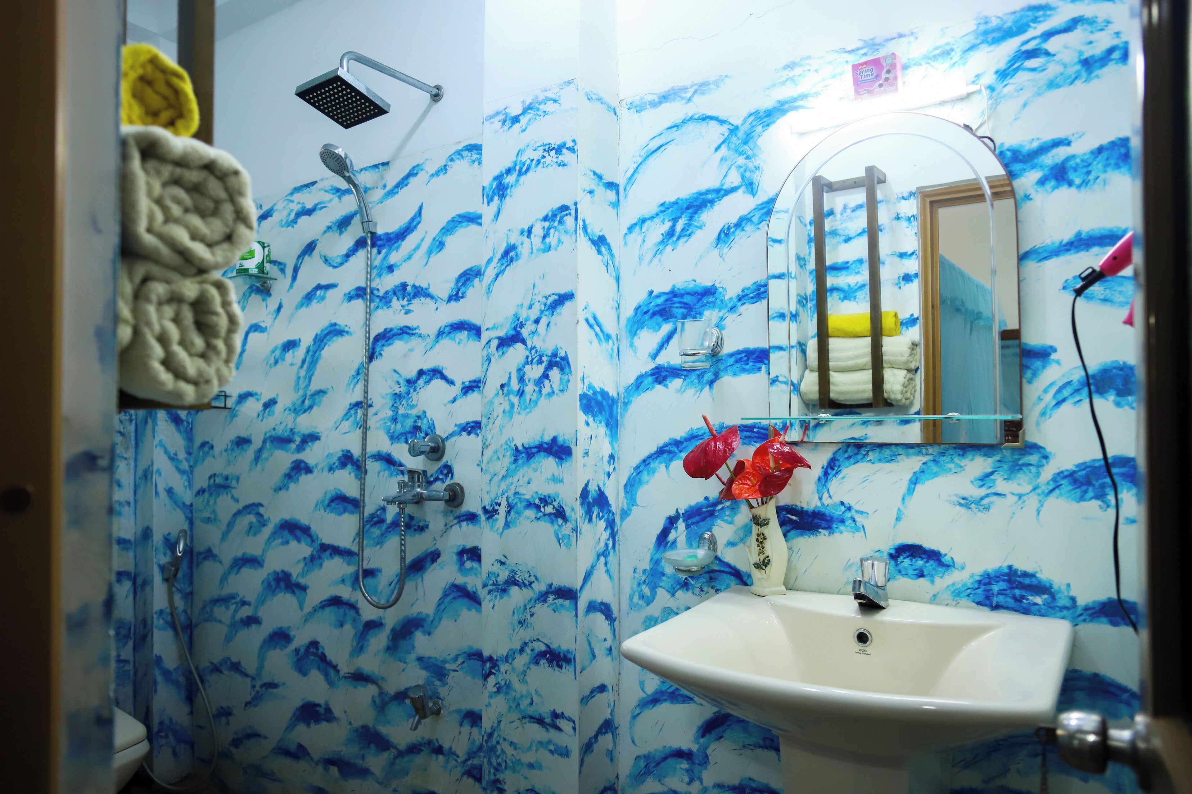 A bathroom with a shower, a sink, and a mirror.