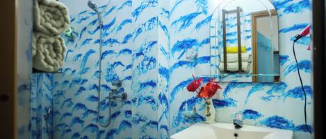 A bathroom with a shower, a sink, and a mirror.