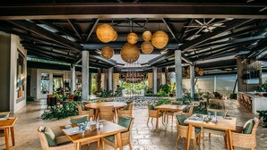 An open-plan restaurant with wicker furniture and hanging spherical light fixtures. - Hotel Three Sixty - Adults Only (Ciudad Cortés)