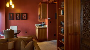 A compact kitchen with wooden cabinetry, a dining area with a round table and chairs, and pendant lighting. - Hotel Mac (Richmond)