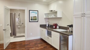 A modern kitchen with wooden flooring, a built-in microwave, and a refrigerator. - Hotel Mac (Richmond)