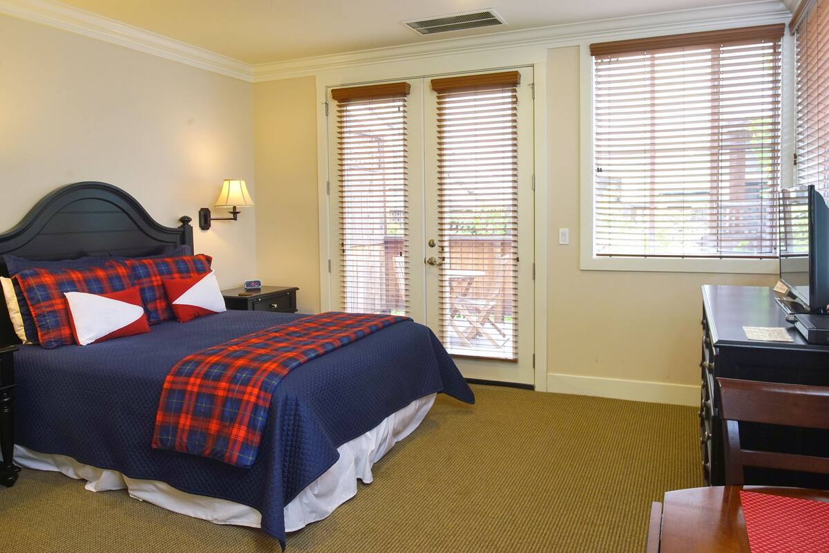 A bedroom with a bed, a desk, and a chair.
