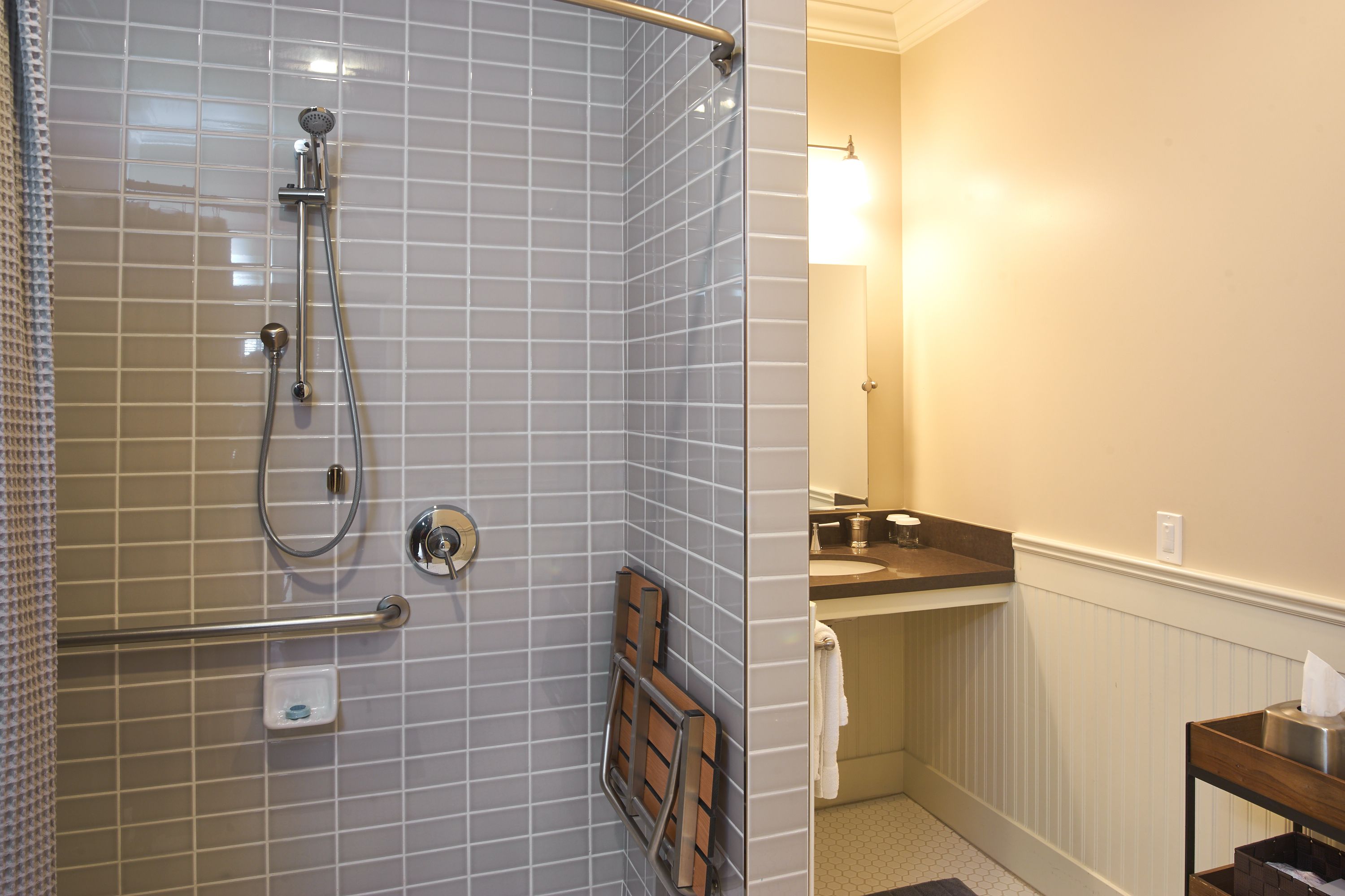 A bathroom with a shower, a sink, and a mirror.