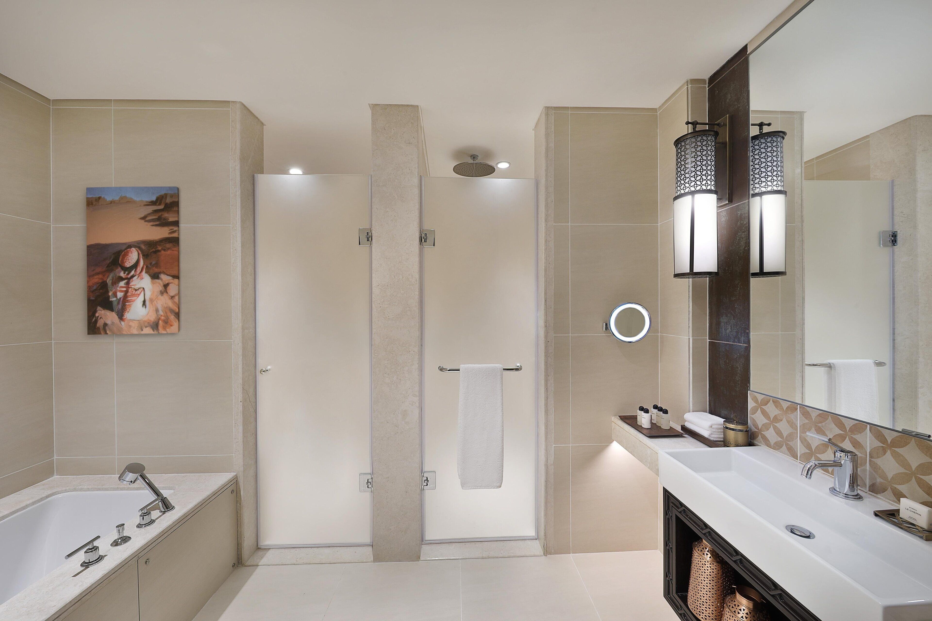 Een moderne badkamer met een bad, een douche en een wastafel.