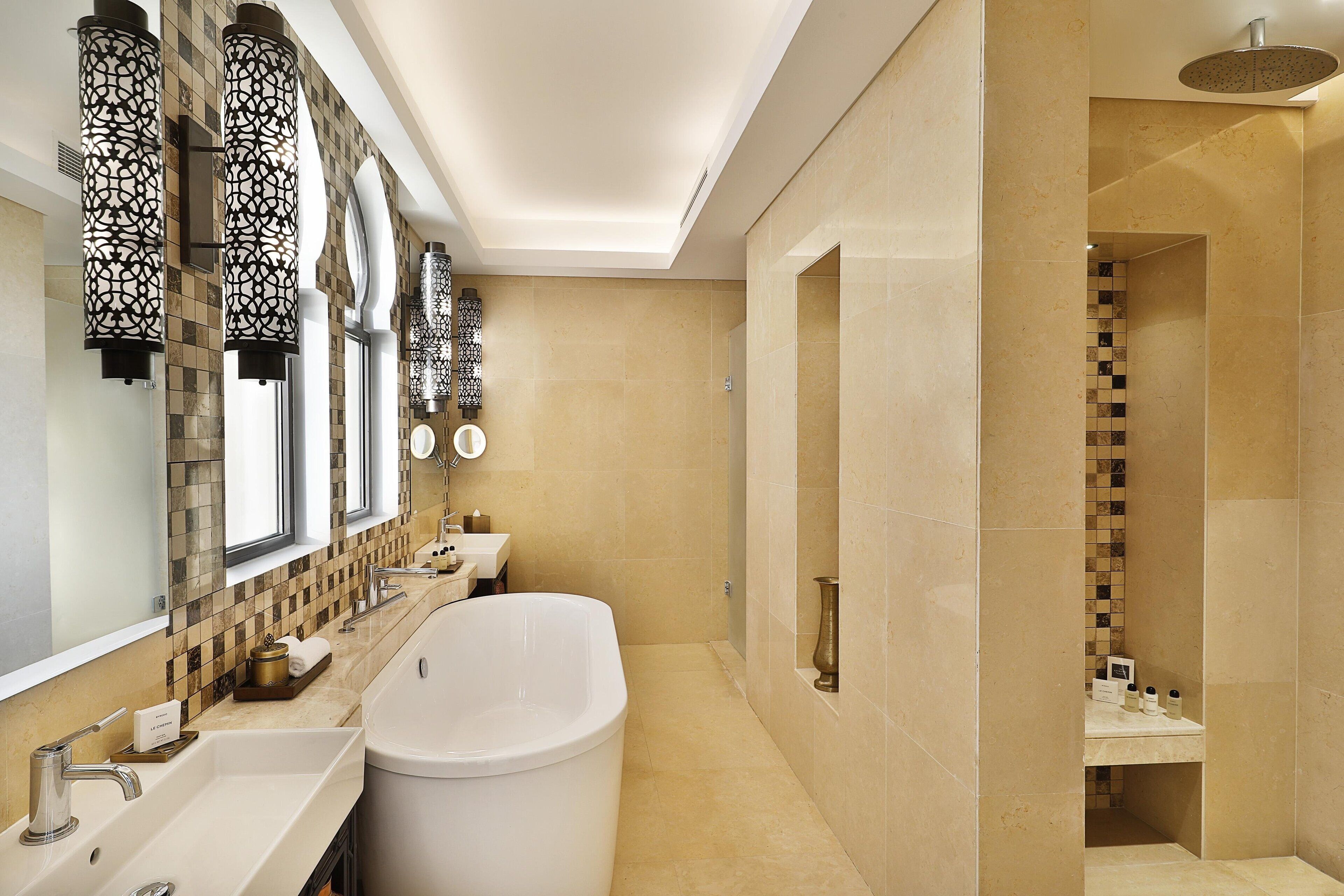 Un baño moderno con una bañera grande, ducha y tocador con espejo.
