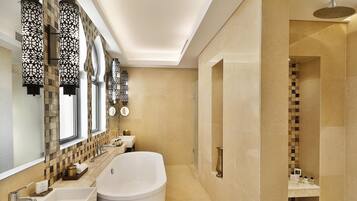 Un baño moderno con una bañera grande, ducha y tocador con espejo.