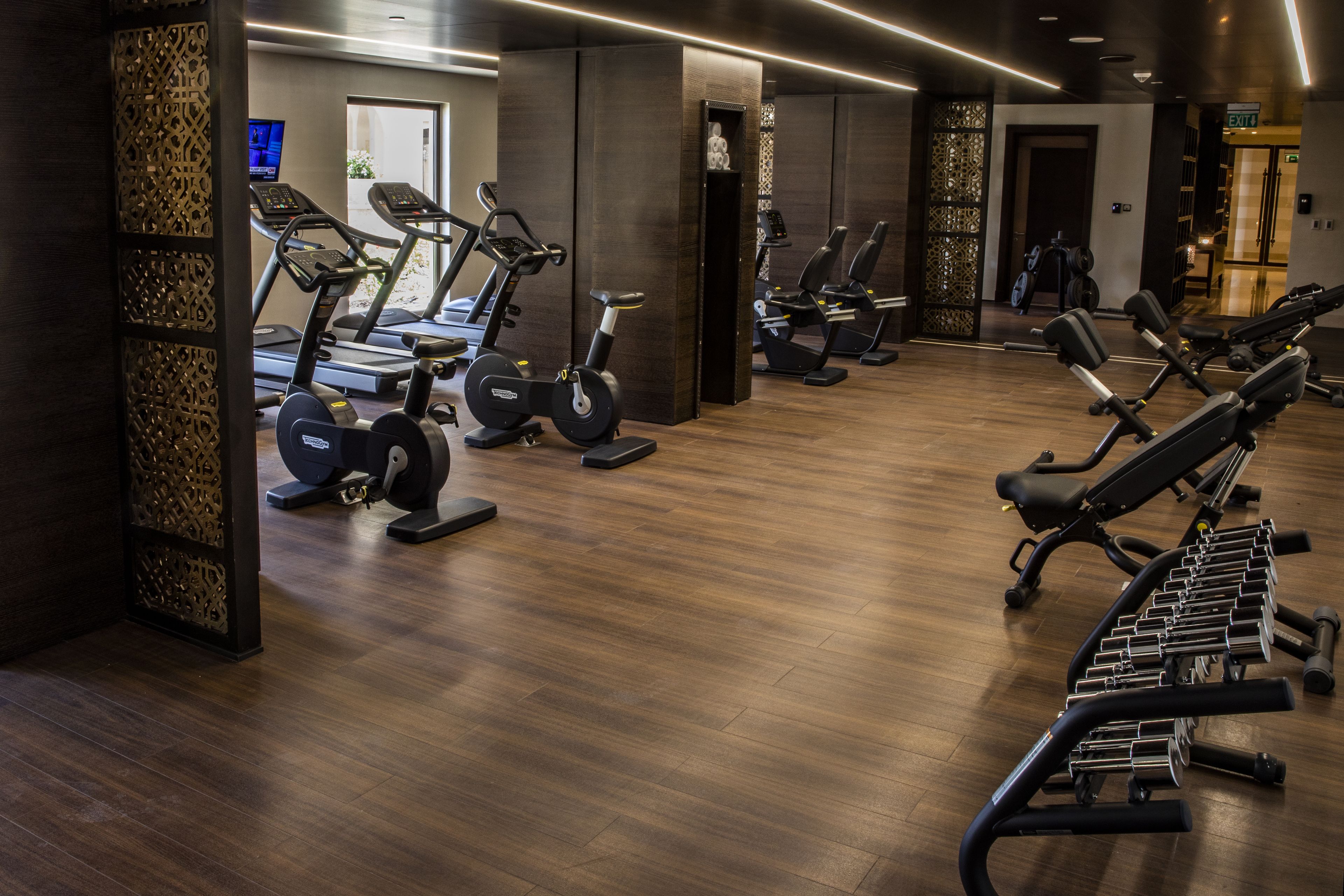 Een sportschool met loopbanden, hometrainers en krachtapparaten.