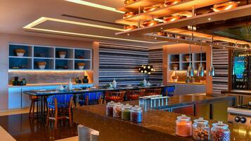 A modern kitchen with a central island, bar seating, and a variety of jars on the counter.