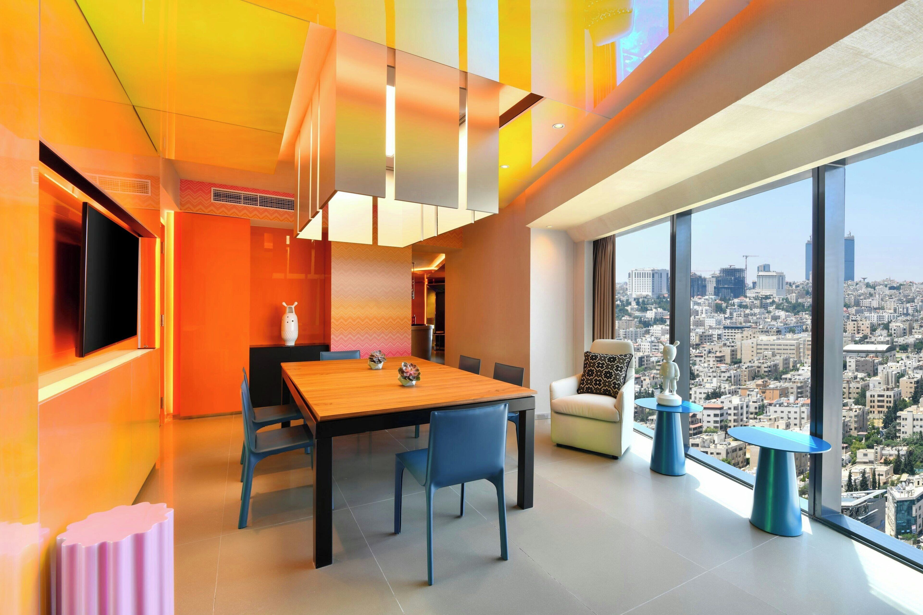 Een modern interieur met een eethoek, een bank en uitzicht op de stad.