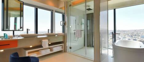 A modern bathroom with a large bathtub, a glass-enclosed shower, and a large mirror.