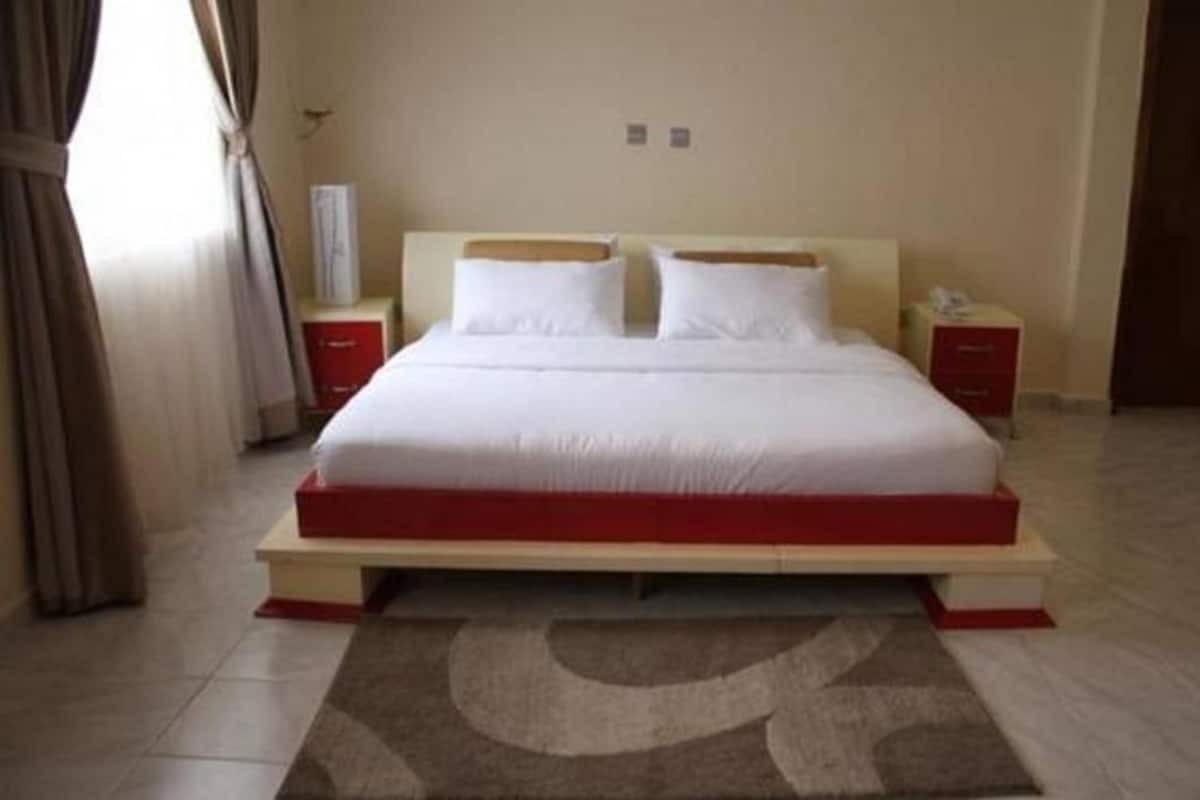 A standard hotel room with a bed, bedside tables, and a rug.