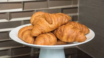 A plate of croissants on a white stand.