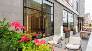 An outdoor seating area with wicker furniture and potted plants.