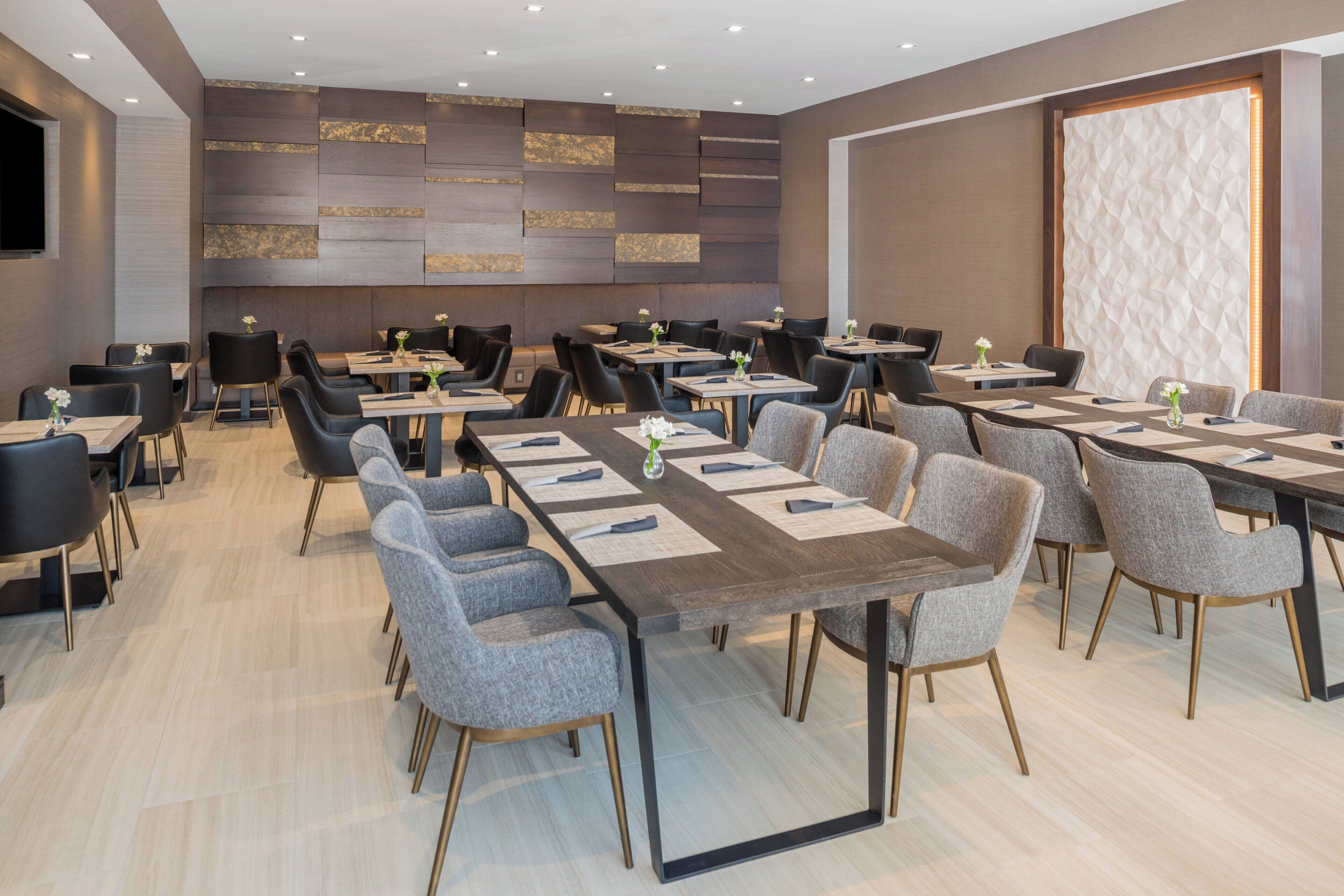 A conference room with multiple tables and chairs, arranged in a U-shape.