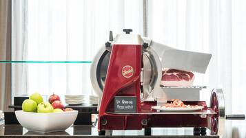 Cuina amb un tallador de pernil, un bol de pomes i un cartell que diu "La Quercia Prosciutto".