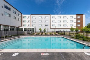 Una piscina al aire libre de temporada, tumbonas