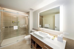 A modern bathroom with a glass-enclosed shower, a white sink, and a large mirror. - Element by Marriott Bentonville (Bentonville)