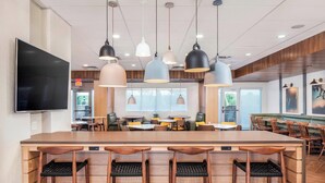 A modern restaurant with a central bar area, multiple seating options, and pendant lighting. - Fairfield Inn & Suites by Marriott Lebanon (Lebanon)