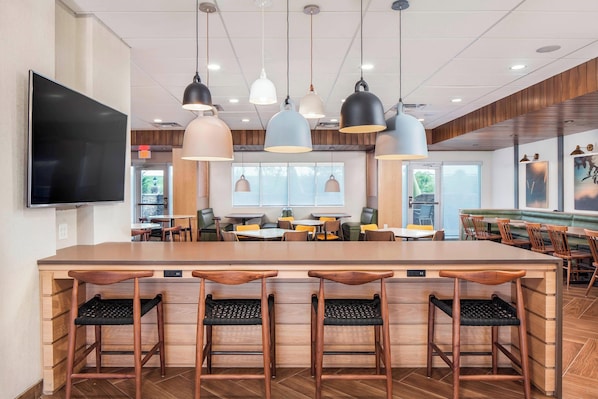 A modern restaurant with a central bar area, multiple seating options, and pendant lighting. - Fairfield Inn & Suites by Marriott Lebanon (Lebanon)